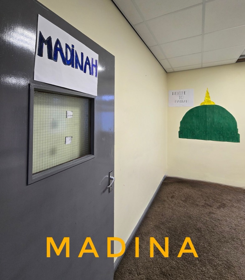A corridor set out as Madina, with a green dome cut from card mounted on the wall